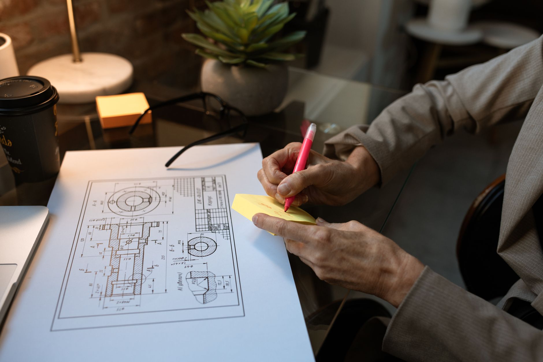 small business owner writing at desk with FAQ notes