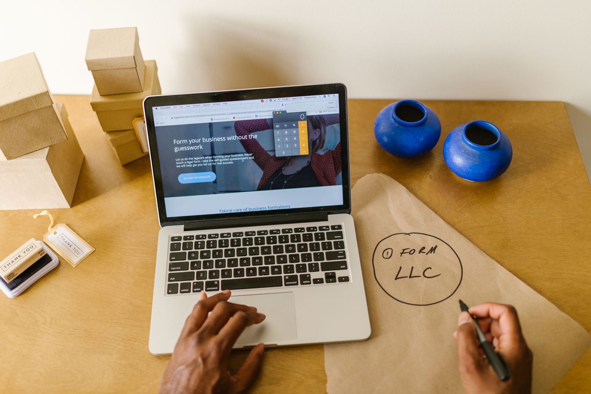 small business owner writing at desk computer